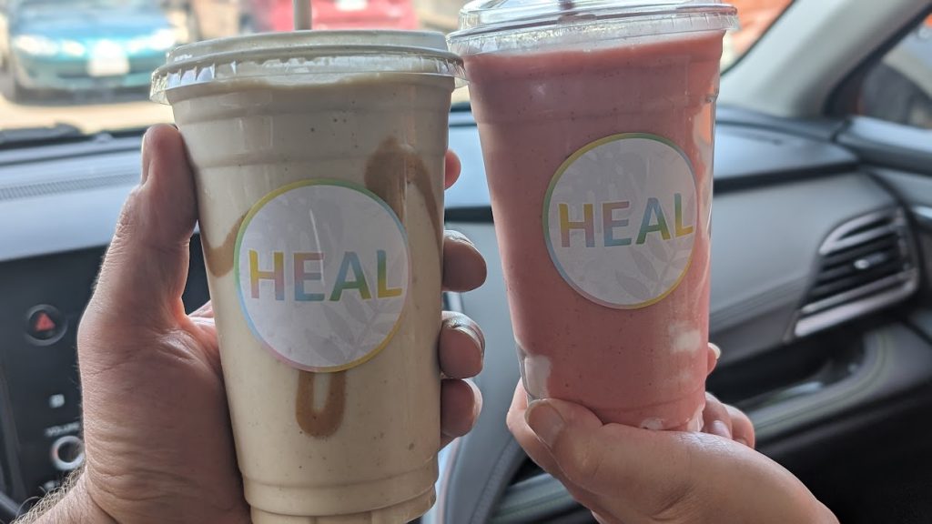 Hands holding up two smoothies from HEAL in Chilliwack.
